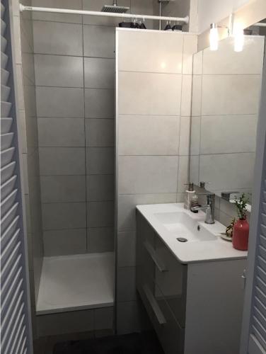 une salle de bain blanche avec un lavabo et une douche dans l'établissement Superbe T2 Carnon Plage, à Mauguio