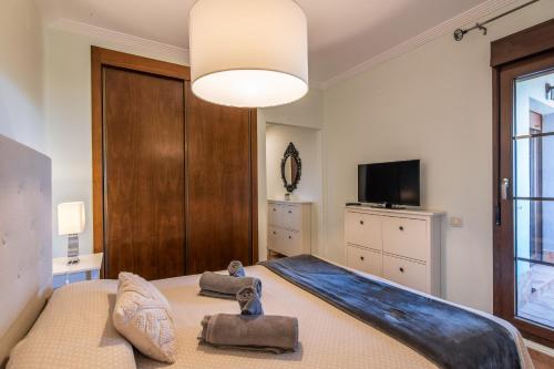 a bedroom with a large bed and a television at Las Palmeras by Ĥ - Playa Punta del Moral PLHP28P11 in Isla del Moral