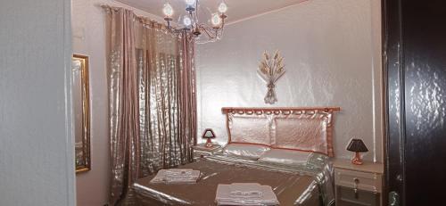 um quarto com uma cama e um lustre em SEGESTA Nouveau Bedding em Salemi