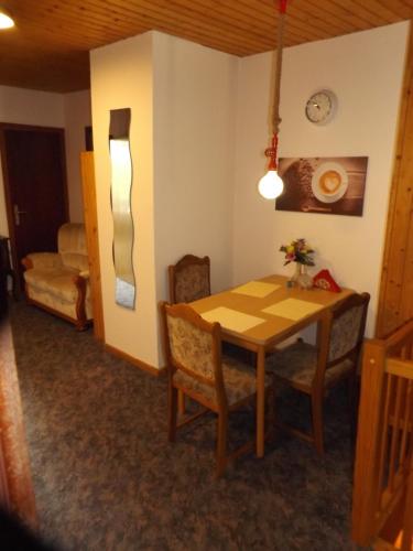 comedor con mesa de madera y sillas en Gästehaus Hahnenkrug, en Lottorf