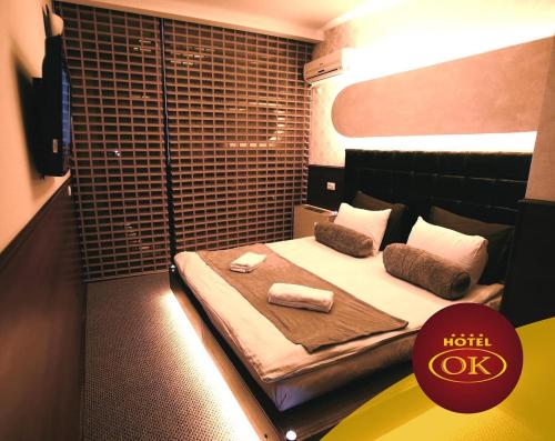 a hotel room with a bed with two towels on it at Hotel OK in Prizren