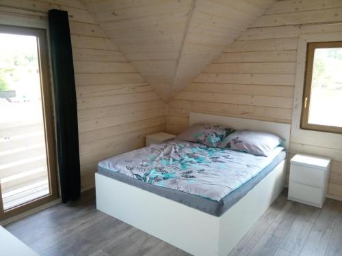 a bedroom with a bed in a wooden cabin at Domki w Krutyni rezerwuj taniej 512-29O-43O rezerwacje tylko telefonicznie www krutyn dzs pl in Krutyń