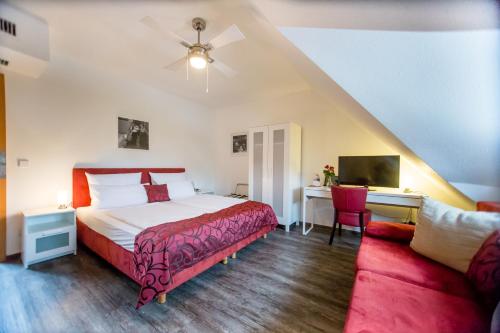 - une chambre avec un lit, un bureau et un canapé dans l'établissement Landhotel zum Baggernpuhl, à Wachow