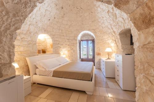 ein Schlafzimmer mit einem Bett in einer Steinmauer in der Unterkunft Tenuta Rifugio Alisha in Locorotondo