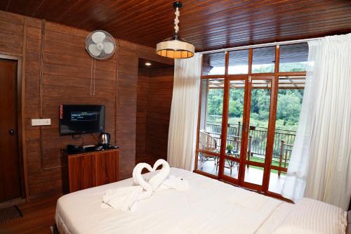 Un dormitorio con una cama con dos cisnes. en Mazhavilkadu ForestResort & Restaurant en Kozhikode