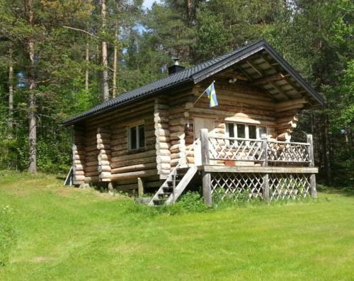 Cabaña de madera en el bosque con porche en Lakeside wilderness cabin en Jokkmokk