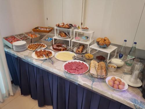 a table topped with plates of food and pastries at Hotel Sissi in Rimini