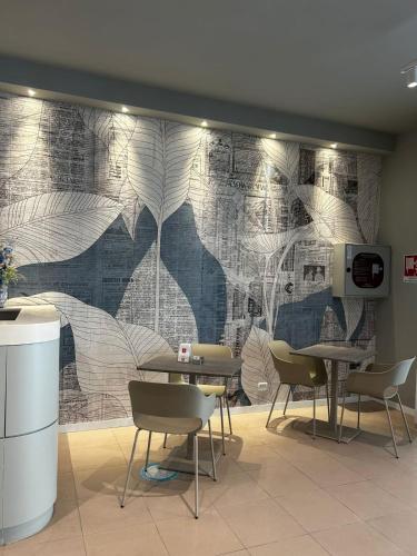 a wall mural in a restaurant with tables and chairs at Hotel Sissi in Rimini