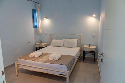 ein Schlafzimmer mit einem Bett mit zwei Handtüchern darauf in der Unterkunft Romanos Xi in Xi