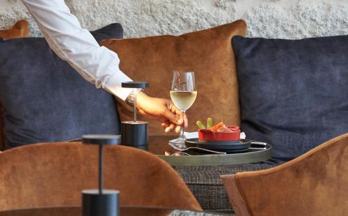 a person holding a glass of wine on a table at PortoBay Flores in Porto