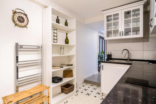 a kitchen with white cabinets and a sink at Convenient Flat w Garden 10 min to Galataport in Istanbul