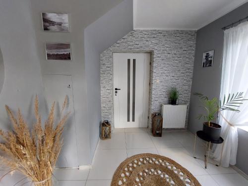 um corredor com uma porta branca e uma parede de tijolos em Pokoje gościnne Na Klifie em Jastrzebia Gora