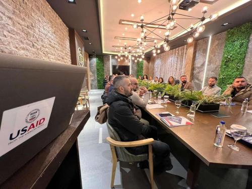 a group of people sitting at a table in a restaurant at Hotel OK in Prizren