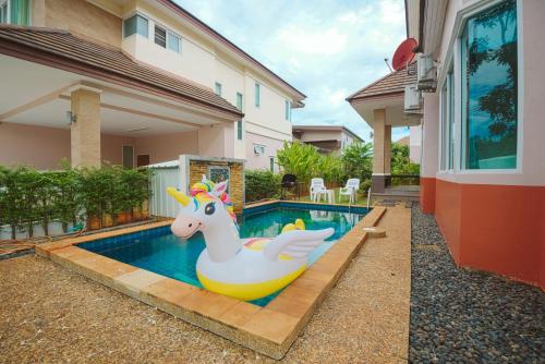 a pool with a unicorn pool noodle in front of a house at June Pool Villa in Krabi