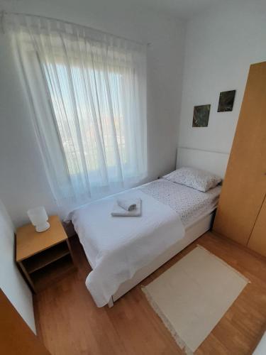 a small bedroom with a bed and a window at Lucija in Pridraga