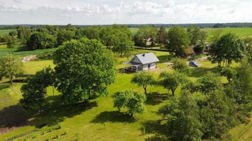 an aerial view of a house in a field with trees at Arimaičių kaimo sodyba 