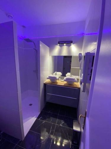 une salle de bain avec un lavabo et un miroir dans l'établissement Gîte Love Dreams Jacuzzi privatif, à Campagnan