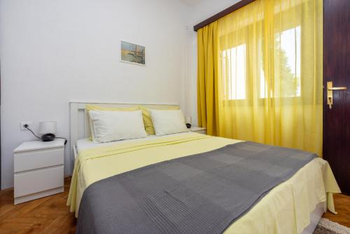 a bedroom with a bed with a yellow curtain at CIRO in Selce