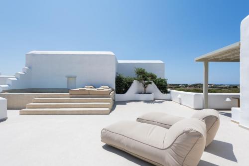 a living room with white furniture and stairs at Sersi Paros Villas & Suites in Kampos Paros