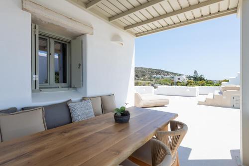 a dining room with a wooden table and chairs at Sersi Paros Villas & Suites in Kampos Paros
