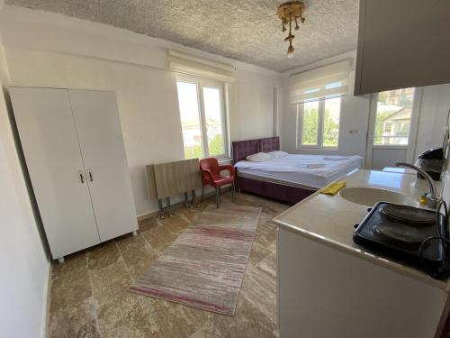 um quarto com uma cama e uma cozinha com um lavatório em KAPADOKYA DELUXE APART em Ürgüp