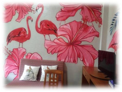 1 dormitorio con flamencos rosas en la pared en ศูนย์ฝึกอบรมสวนสัตว์เปิดเขาเขียว JJJ, 