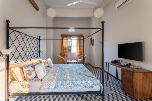 a bedroom with a bed and a flat screen tv at Kol Pol Mohalla Boutique Stay in Udaipur