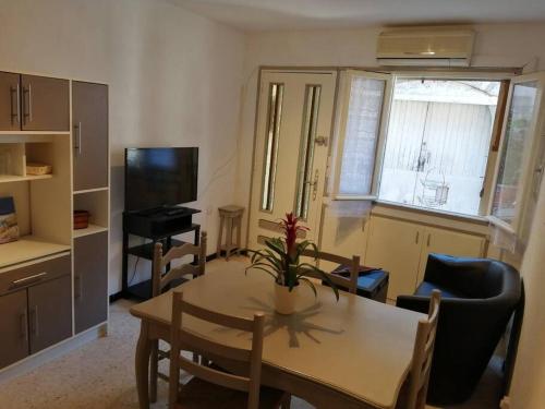 a small living room with a table and a television at L'OUSTAL DE FLO in Florensac