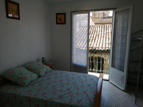 um quarto com uma cama e uma grande janela em L'OUSTAL DE FLO em Florensac
