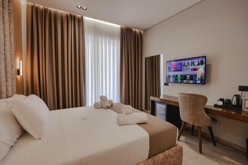 Pokój hotelowy z łóżkiem, biurkiem i telewizorem w obiekcie The Lord Hotel w mieście Ksamil
