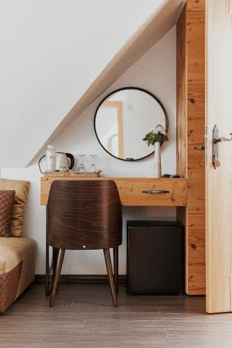 a vanity with a mirror and a chair in a room at Toplik Village Resort in Lukavica