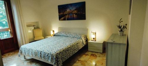 ein Schlafzimmer mit einem Bett, einem Tisch und einem Bild in der Unterkunft Primetta House in Florenz