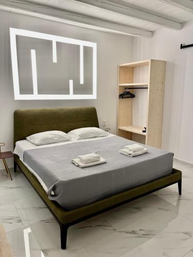 a bedroom with a bed with two towels on it at Casa Nostra Mykonos Boutique Rooms & Studios in Glastros