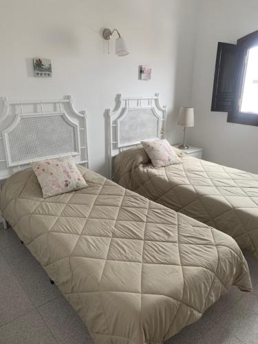 two beds sitting next to each other in a bedroom at Casa Nehuna in Orzola