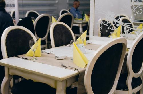 a table with yellow napkins on top of it at Arena Bakarni in Brčko