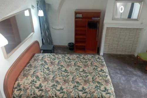 a bedroom with a bed and a dresser at Appartement entier, La Chacuniere in Saint-Amant-Tallende