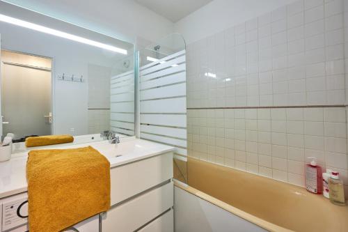 een badkamer met een wastafel, een douche en een bad bij Le Tikahupo - Charmant appt vue sur le port in Courseulles-sur-Mer