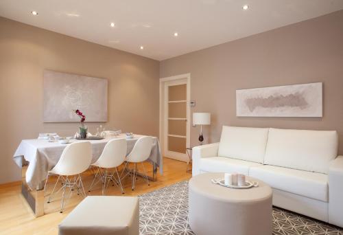 sala de estar con mesa y sofá blanco en Stay U-nique Apartments Sepulveda, en Barcelona