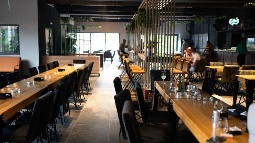 a restaurant with long tables and chairs and people sitting at tables at Arena Bakarni in Brčko