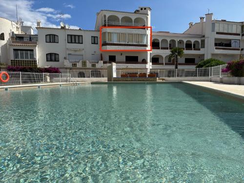 una gran piscina de agua frente a un edificio en LAppart Empuriabrava, en Empuriabrava