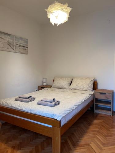 a bedroom with a bed with two towels on it at City life apartman in Herceg-Novi