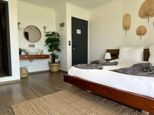 a bedroom with a bed and a bathroom with a sink at Li Mango in Tigaki
