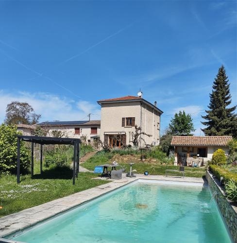 a swimming pool in front of a house at Le Marais des Littes in Chonas-lʼAmballan