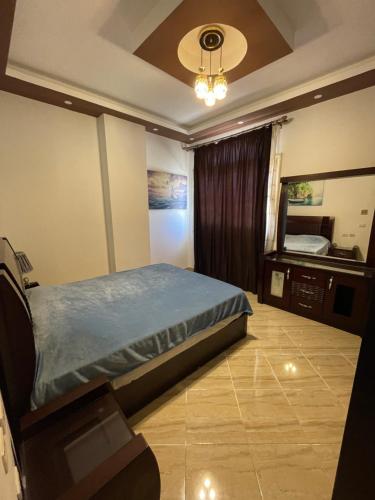 a bedroom with a bed and a dresser and a mirror at El Andalous Apartments in Hurghada