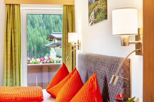 a hotel room with orange pillows and a window at Haus Alpenheim Apartment 3 in Tux