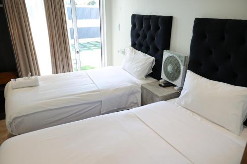 a hotel room with two beds and a television at El-Gibor Best Guest House in Cape Town