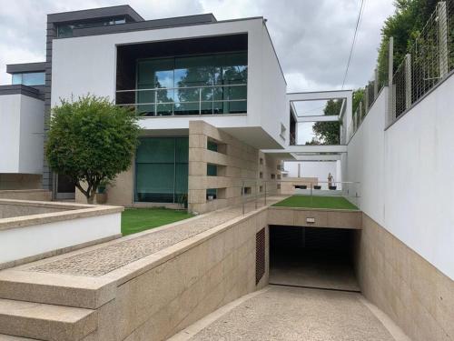 een modern huis met een loopbrug ervoor bij Moradia Lux RR com piscina in Penafiel