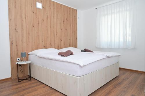 uma cama grande num quarto com uma parede de madeira em Villa Anita em Jajce
