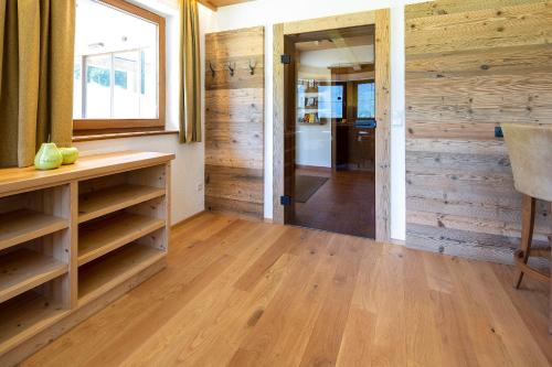 a living room with wooden walls and wooden floors at Landhaus Obertuschenhof in Pertisau