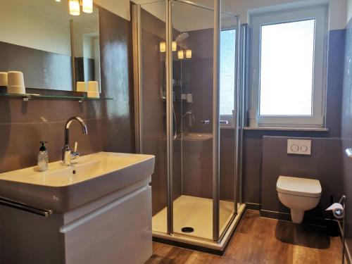 a bathroom with a shower and a sink and a toilet at Ferienhaus Rosenboom Rosenboom 02 in Norderney